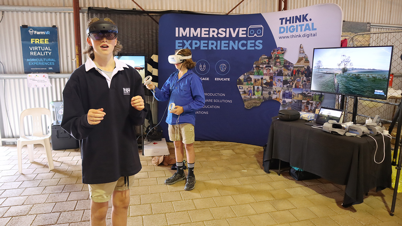 A boy wearing an AR headset in the foreground and a boy wearing a VR headset in the background; the "Think Digital" banner is clearly visible behind them.